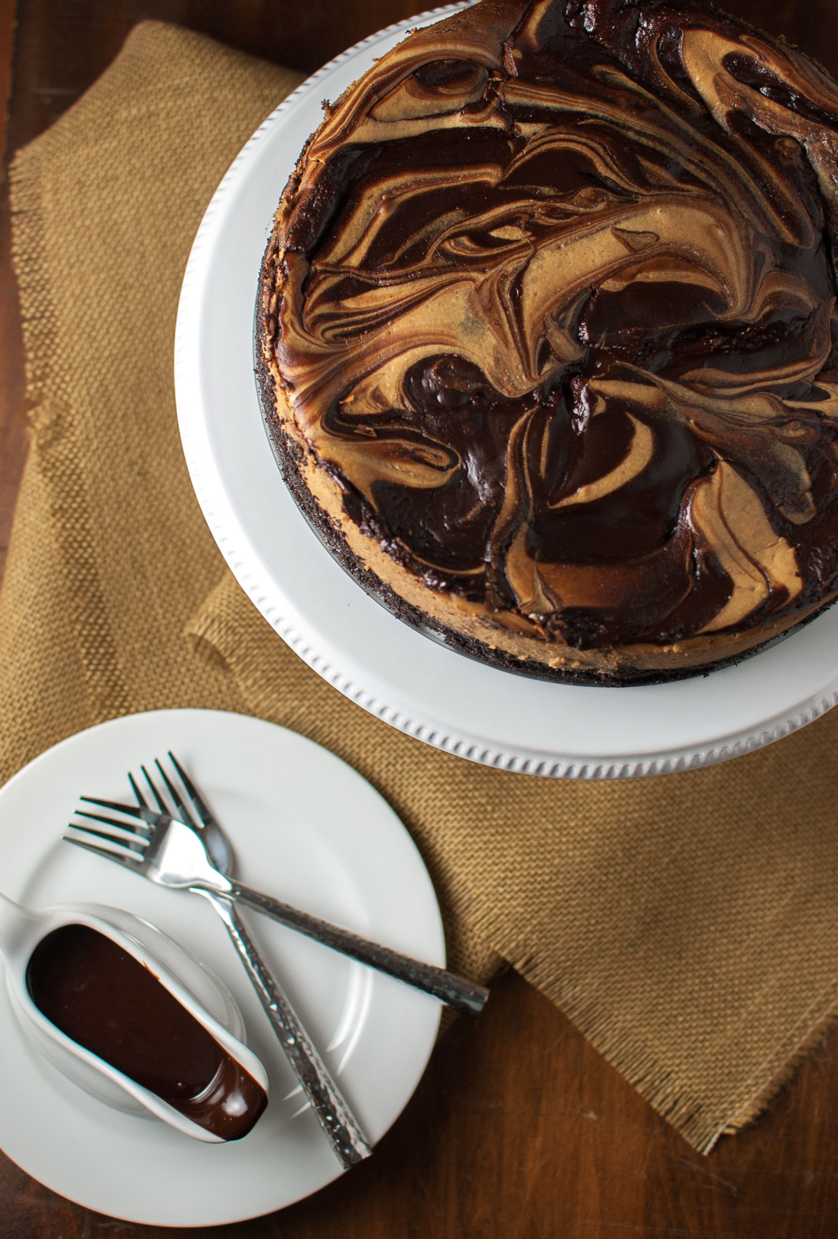 Cappuccino marble cheesecake next to a small bowl of fudge sauce.