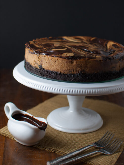 Cappuccino marble cheesecake on a white cake stand.