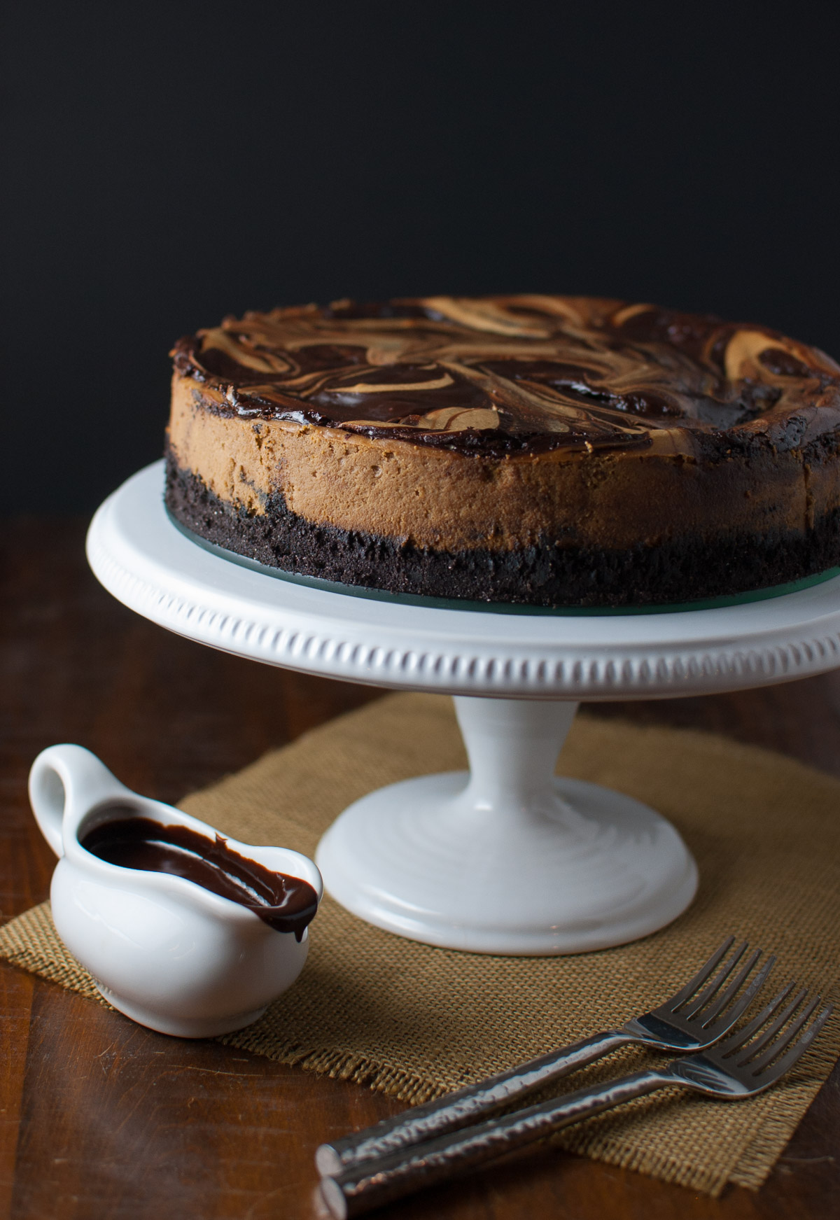Cappuccino marble cheesecake on a white cake stand.