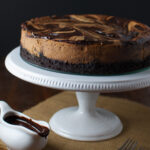 Cappuccino marble cheesecake on a white cake stand.