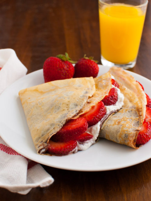 Crêpes filled with strawberries, whipped cream, and nutellas.