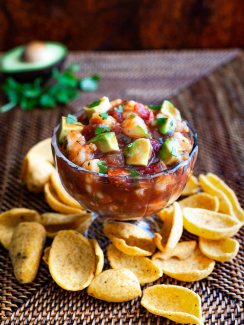 A bowl of shrimp campechana served with some frito chips.