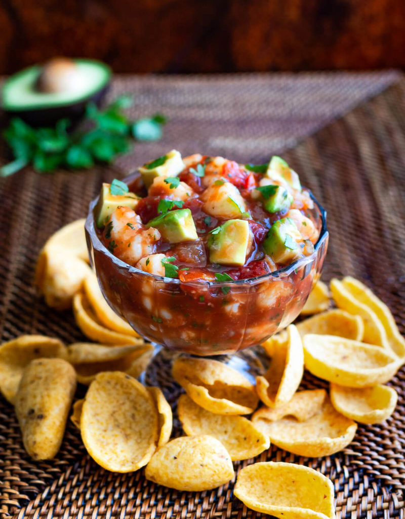 A bowl of shrimp campechana served with some frito chips.