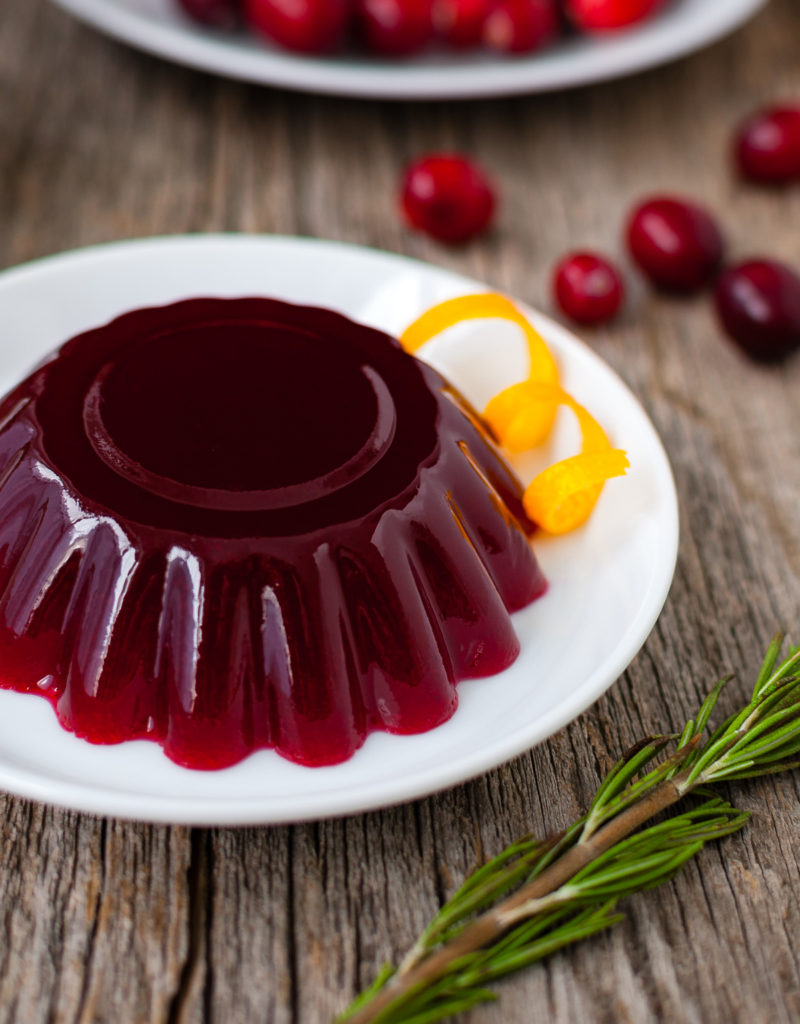 Molded cranberry jelly on a white plate.