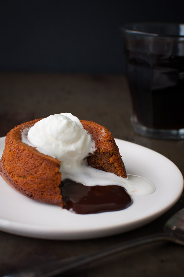 Chocolate cake with melted chocolate on the inside and topped with whipped cream.
