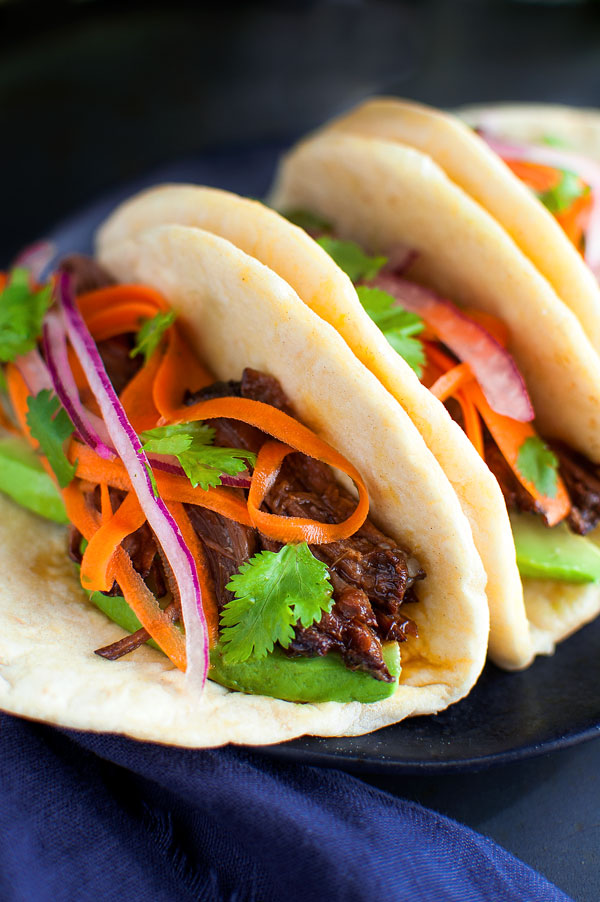 Korean Beef Tacos - These beef tacos are juicy, super tender and so easy to make in the slow-cooker. A tangy carrot and red onion slaw is the perfect balance for the sweet-smoky flavor of the beef. | stg-tamingofthespooncom-staging.kinsta.cloud