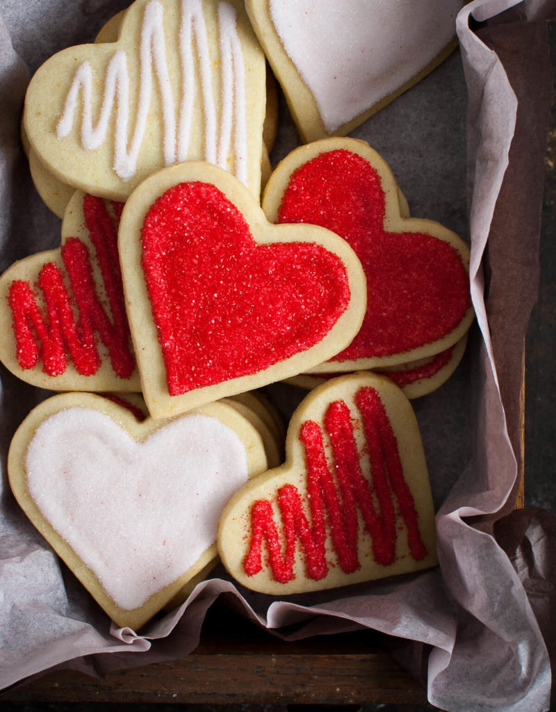 Decorated heart shaped sugar cookies in a tissue lined box.