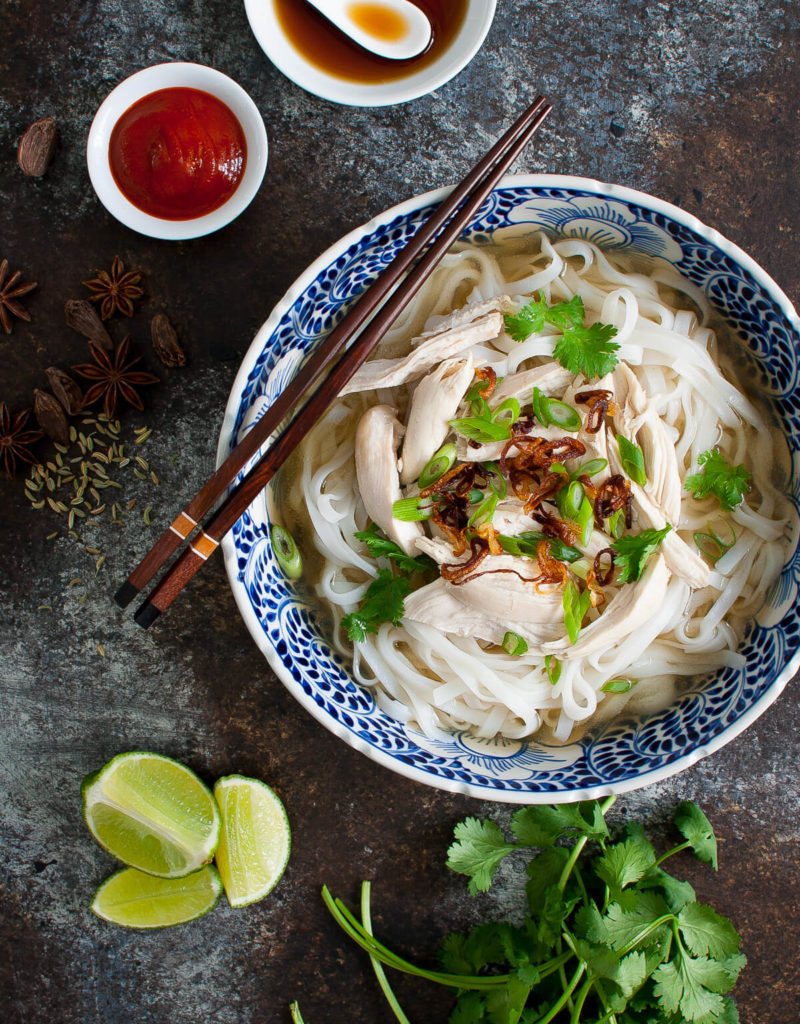 Overhead view of a bowl of chicken pho garnished with fried shallots and cilantro.