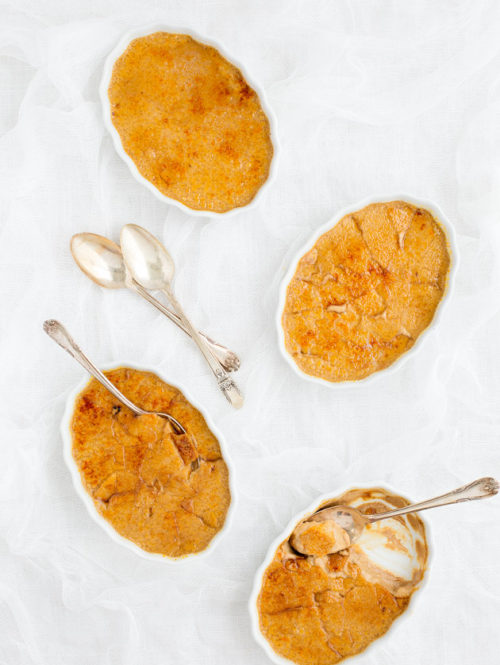 Overhead view of pumpkin spice latte crème brûlée in four white ramekins.