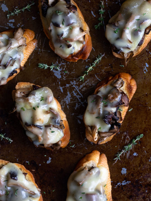 Roasted mushrooms and melted cheese on toasted bread slices.