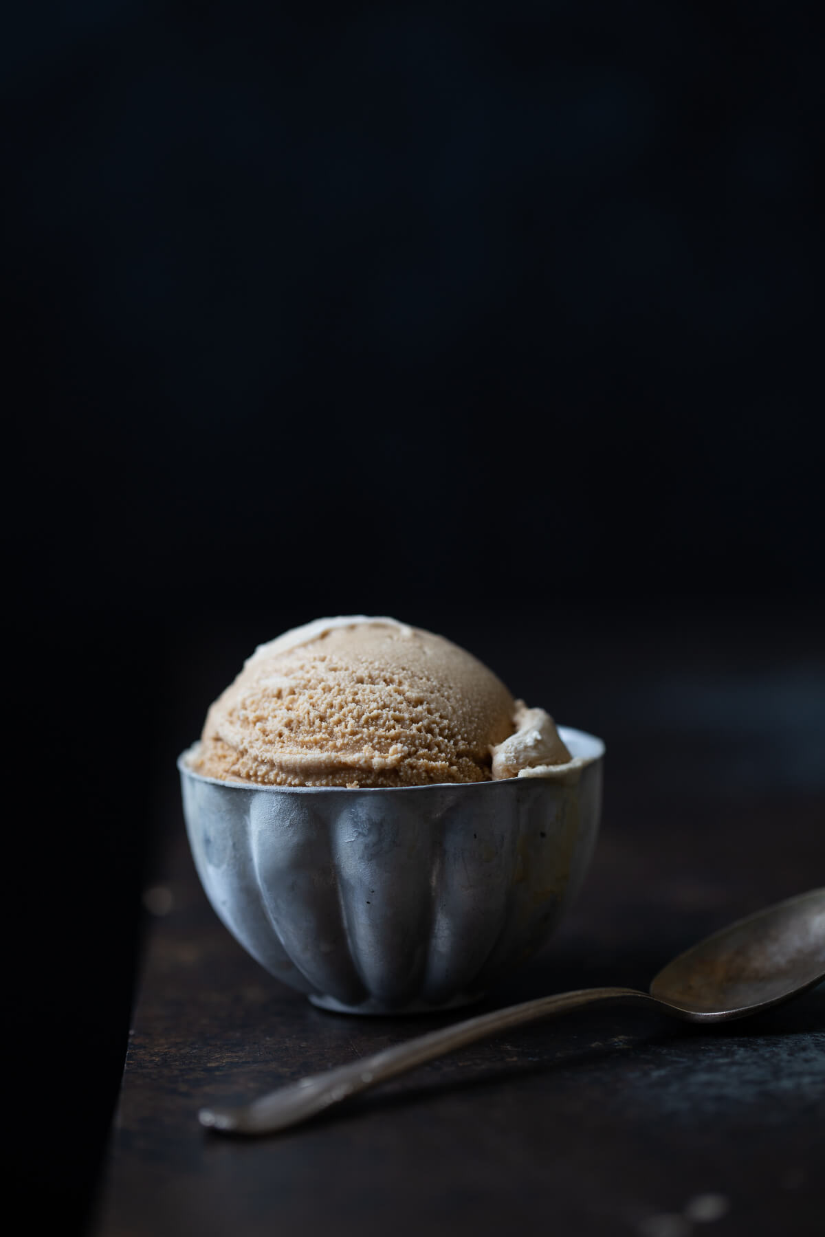 Vietnamese coffee ice-cream in a metal bowl with a spoon.