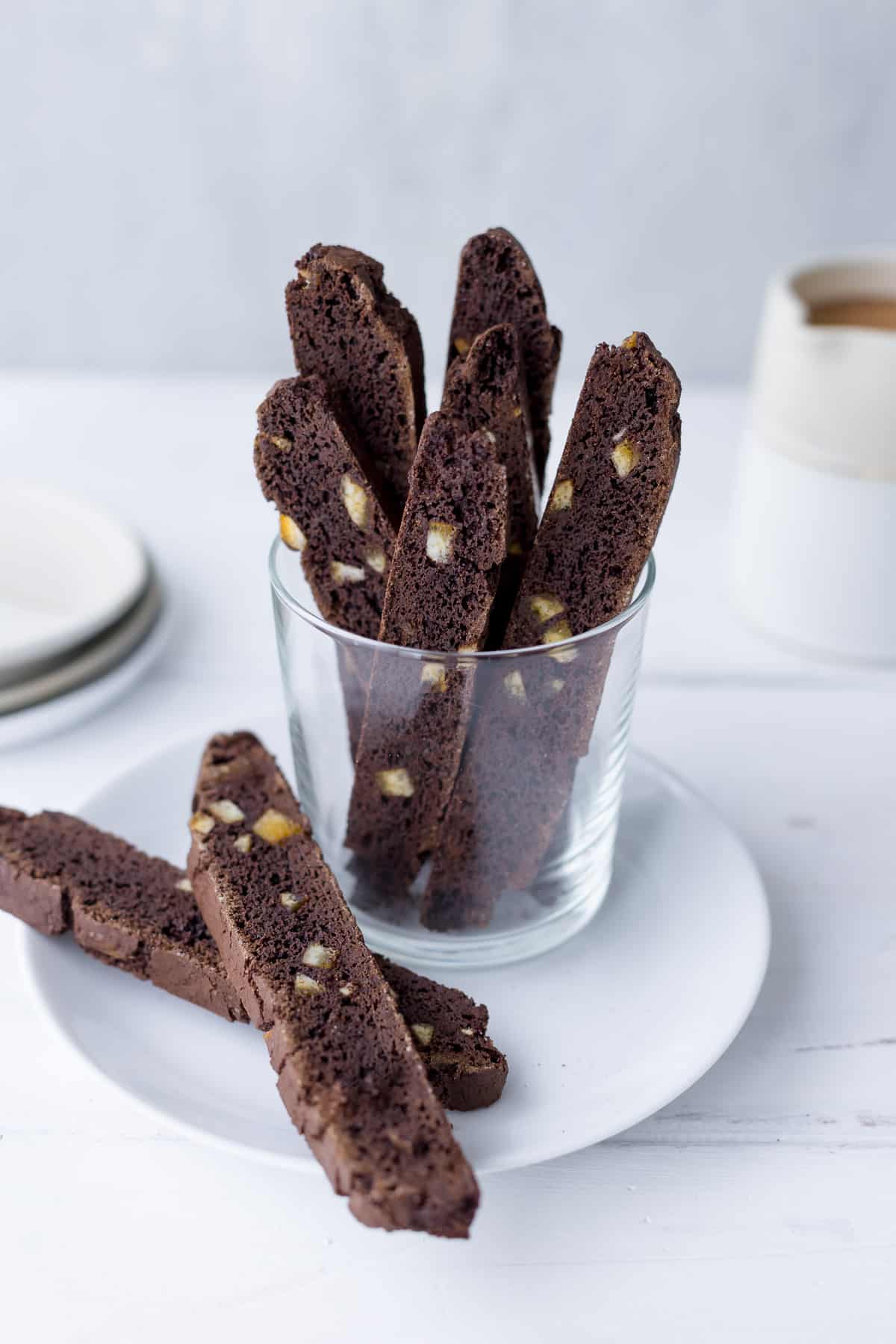 Chocolate-orange biscotti in a glass on a white plate.