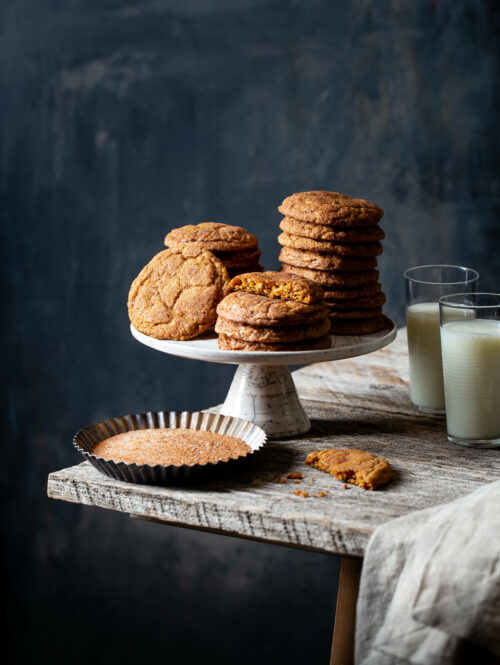 Stacks of pumpkin snickerdoodle cookies on a cake stand.