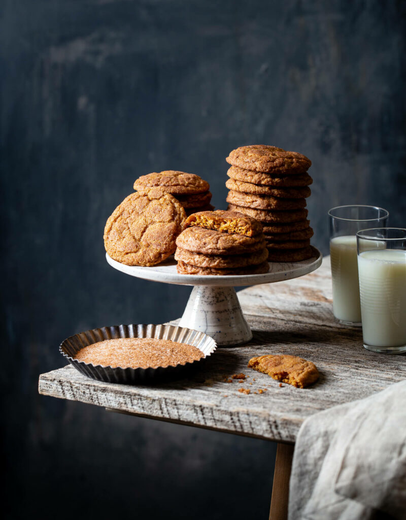 Stacks of pumpkin snickerdoodle cookies on a cake stand.