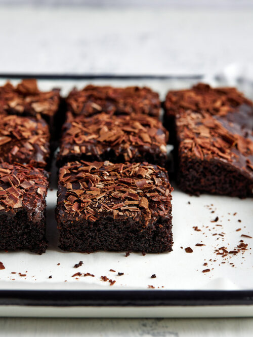 Slices of chocolate sheet cake on a white tray.