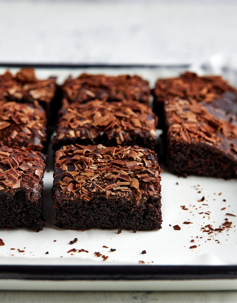 Slices of chocolate sheet cake on a white tray.