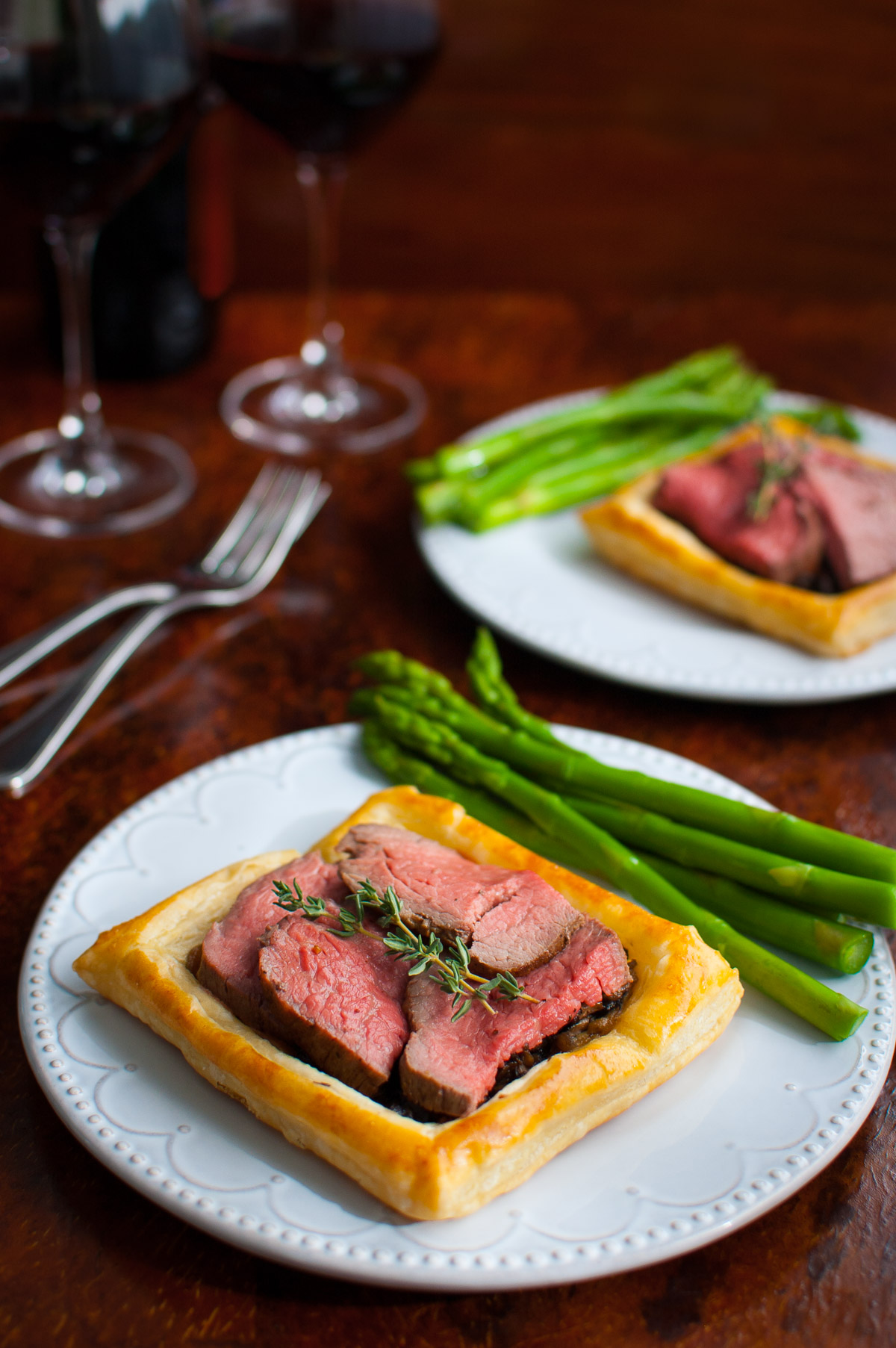 Beef Wellington tarts served with asparagus.