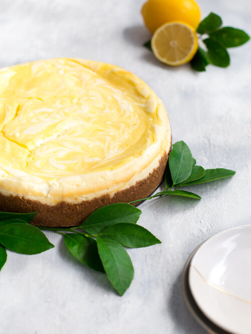 A lemon curd marbled cheesecake garnished with lemon leaves.