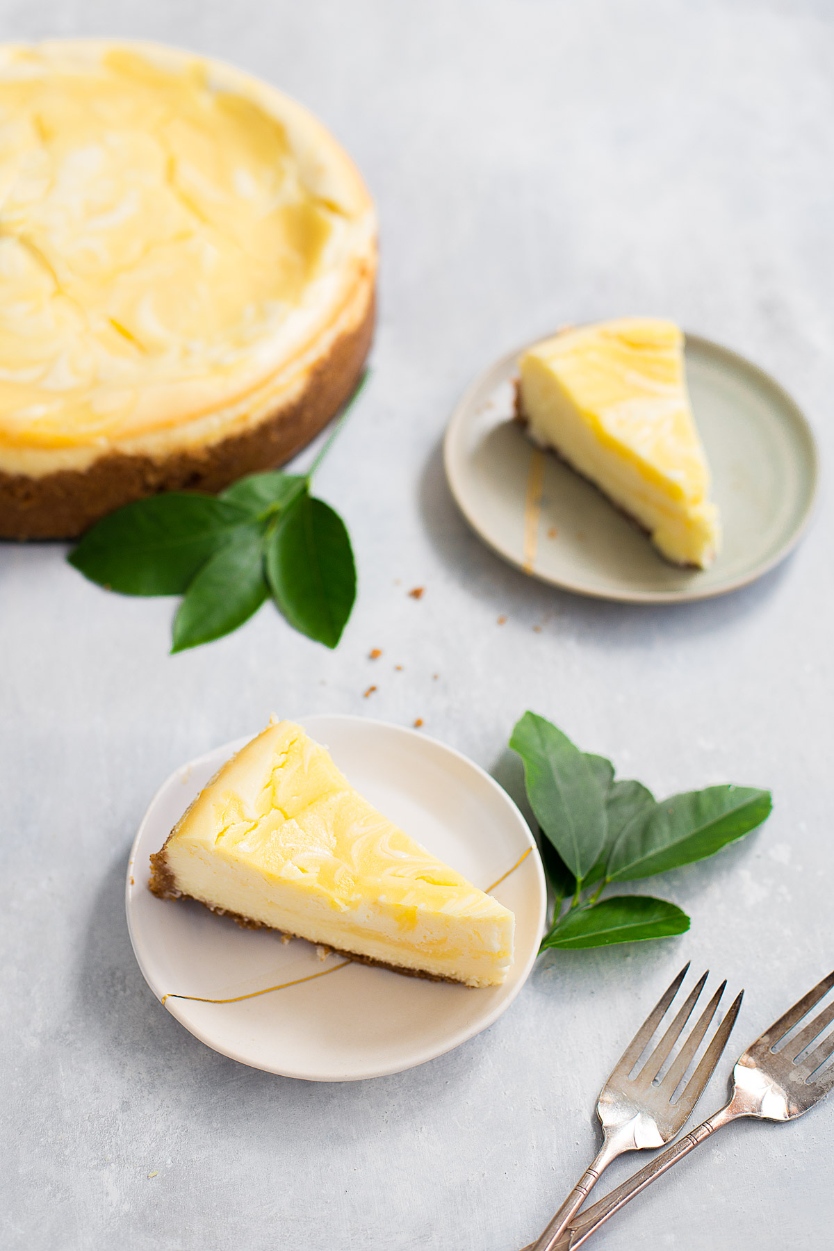 Slices of lemon curd marbled cheesecake on small dessert plates.