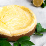 A lemon curd marbled cheesecake garnished with lemon leaves.