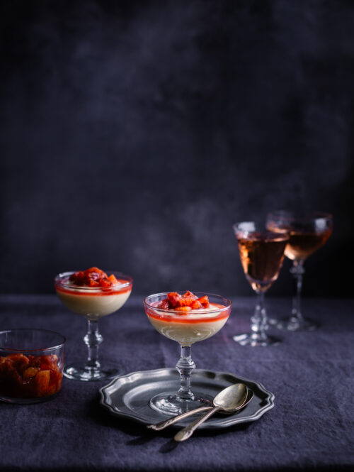 Vanilla pudding in a coupe glass on a pewter plate.