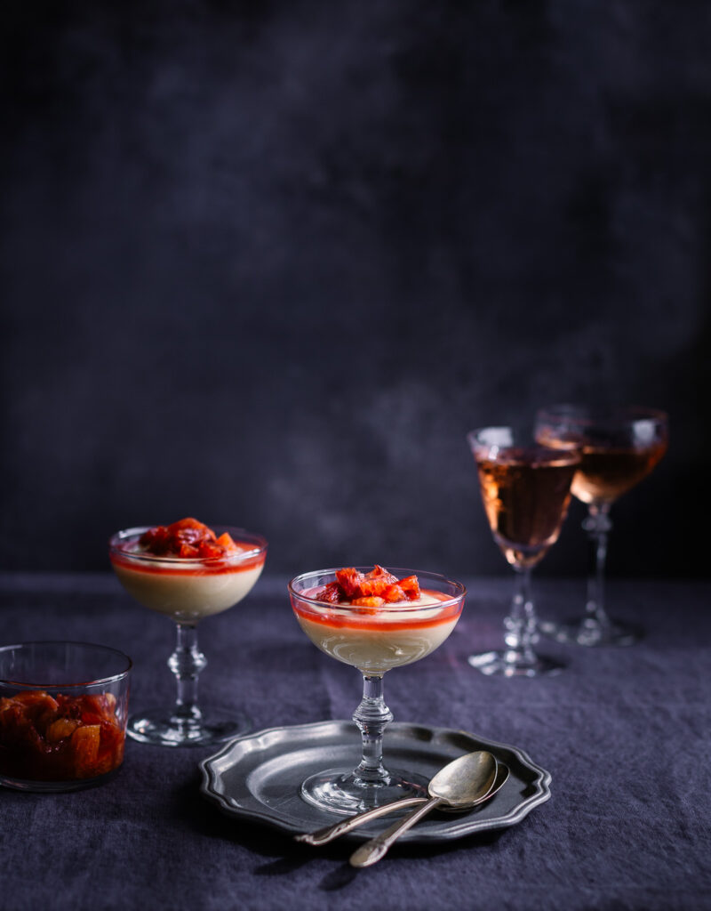 Vanilla pudding in a coupe glass on a pewter plate.