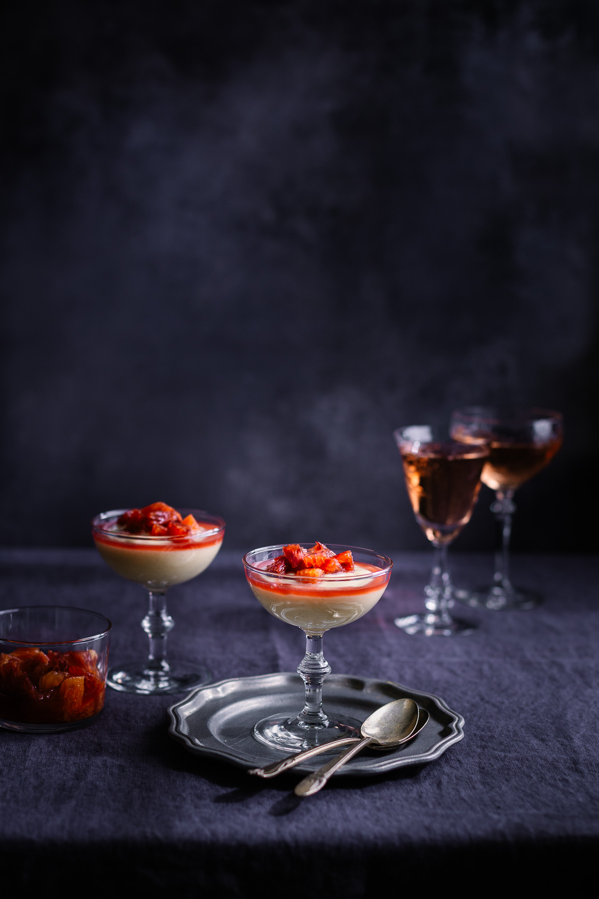 Vanilla pudding in a coupe glass on a pewter plate.