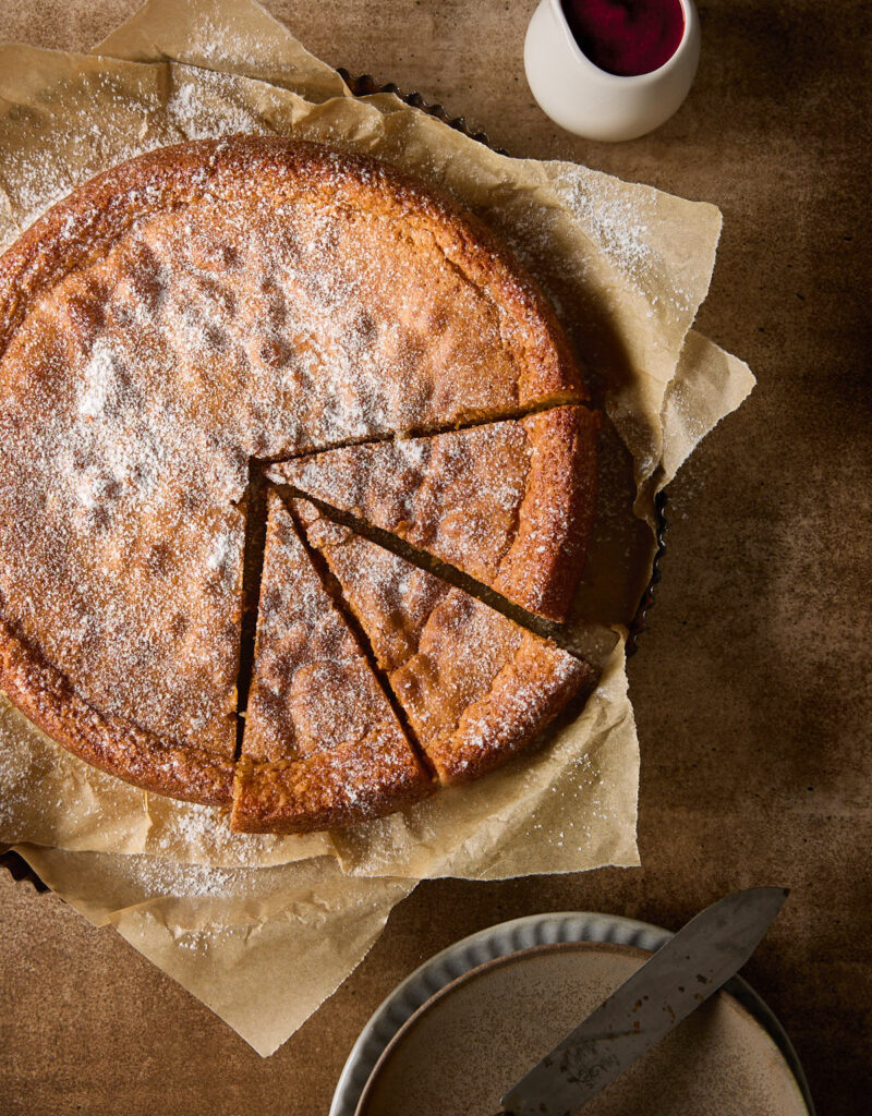 Almond torte with three slices cut.