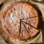 Almond torte with three slices cut.