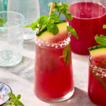 Close-up of glass of watermelon mocktail garnished with fresh mint.