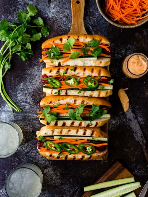 Hot dogs topped with pickled carrots, cilantro, and sriracha mayo.