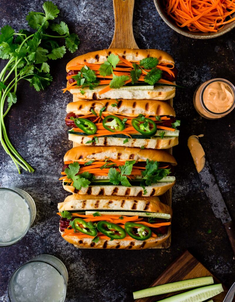 Hot dogs topped with pickled carrots, cilantro, and sriracha mayo.