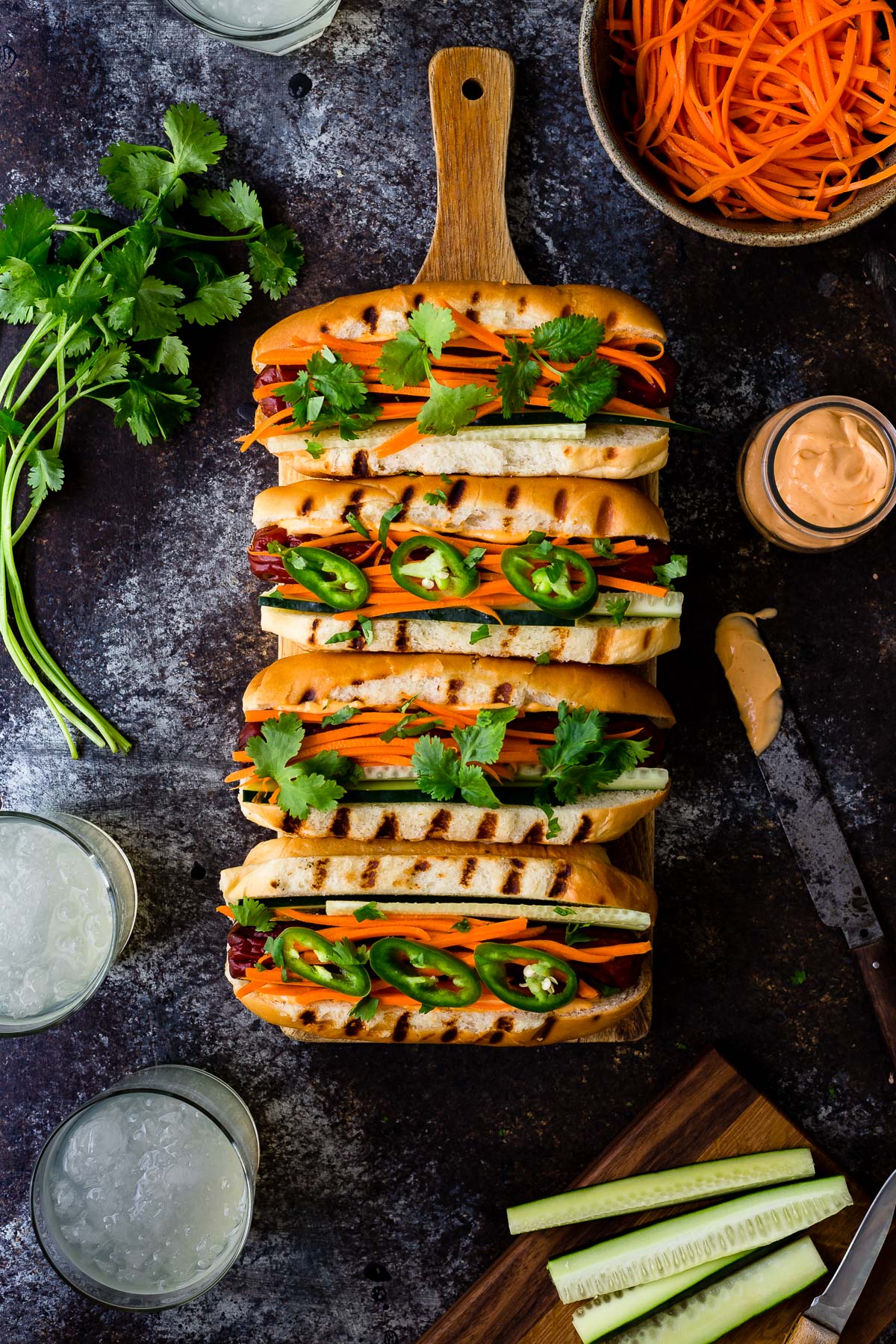 Hot dogs topped with pickled carrots, cilantro, and sriracha mayo.