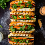 Hot dogs topped with pickled carrots, cilantro, and sriracha mayo.