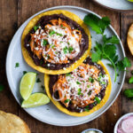 Tostadas topped with refried beans, shredded chicken, pickled shallots, and cotija cheese.