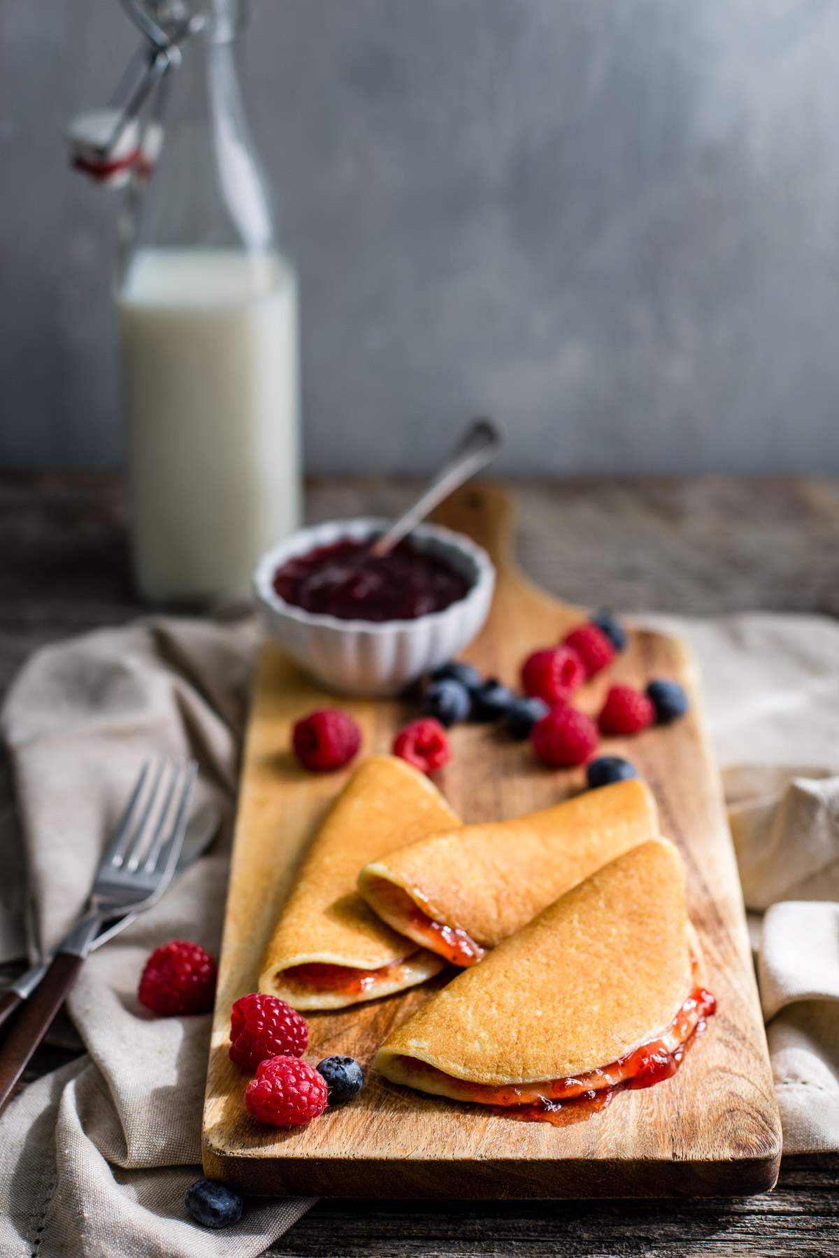 Cottage cheese pancakes served with berries and strawberry jam.