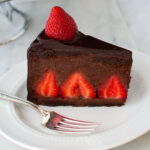 A slice of chocolate strawberry mousse cake on a white plate.