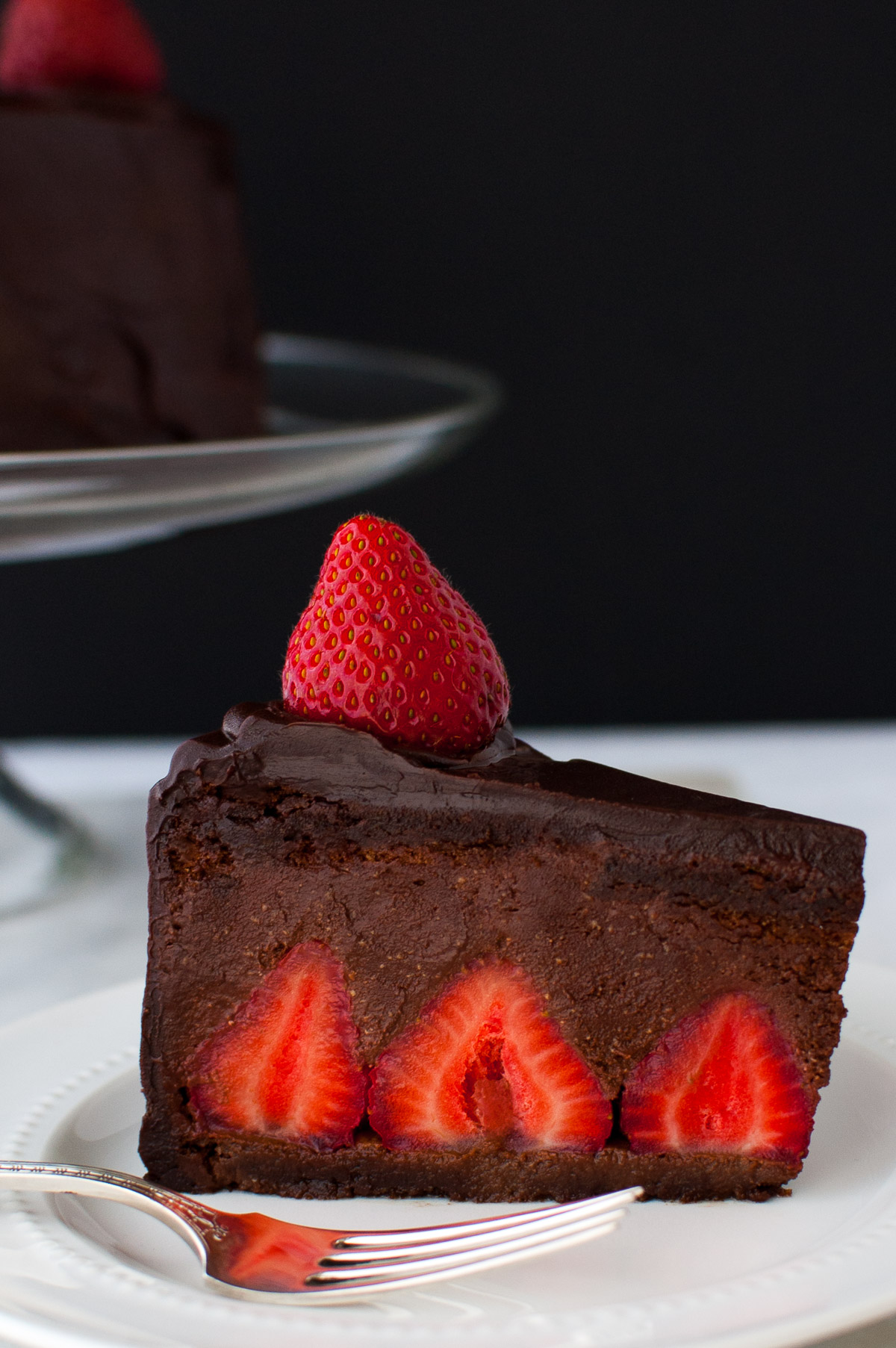 A slice of chocolate strawberry mousse cake on a white plate