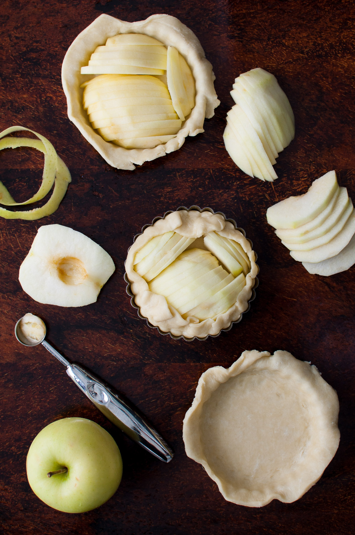 Overhead view showing steps to assemble an apple tartlet.