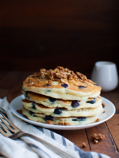 A stack of blueberry pancakes topped with some streusel.