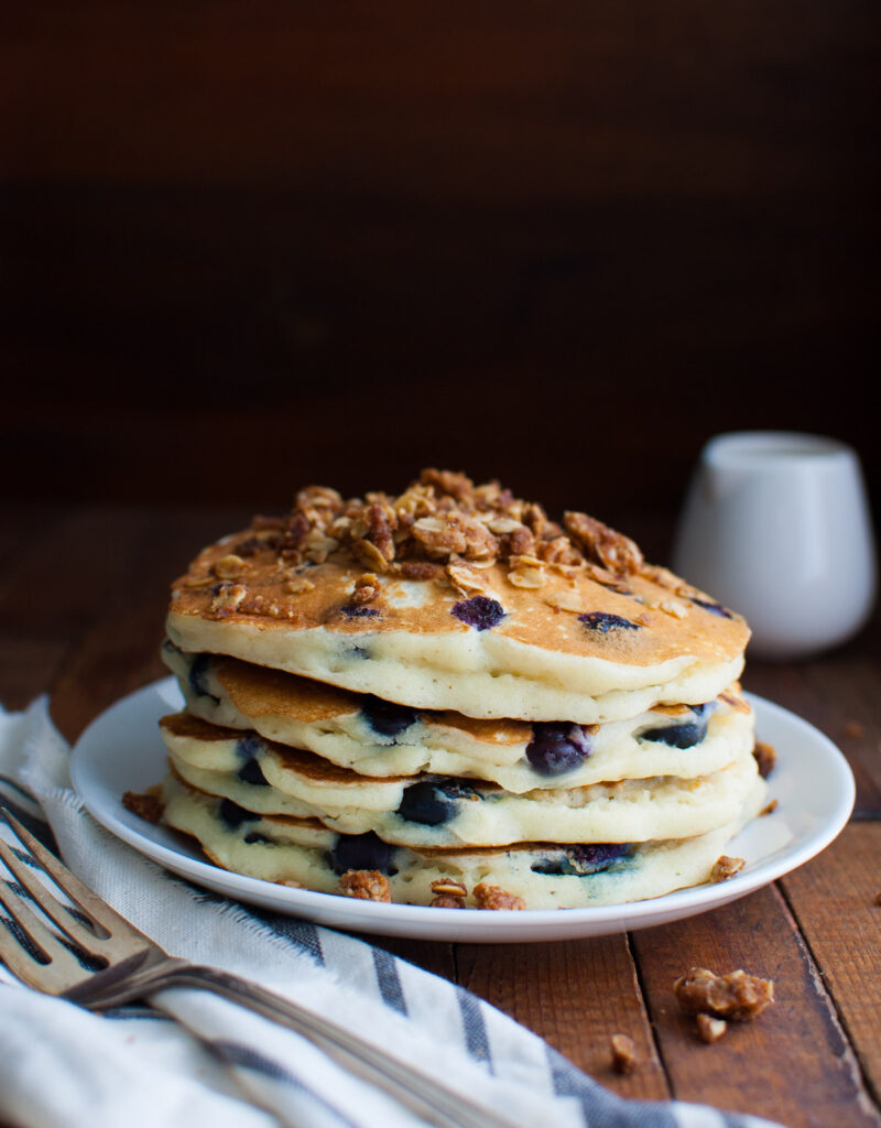 A stack of blueberry pancakes topped with some streusel.