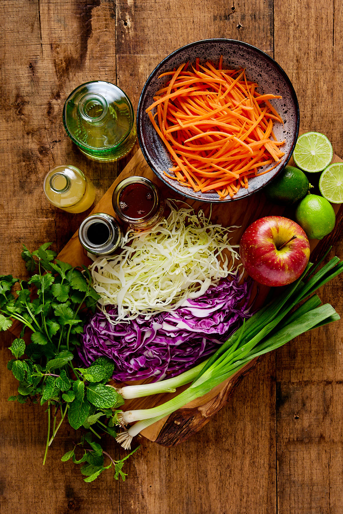 Ingredients for making cabbage slaw on a wooden board.