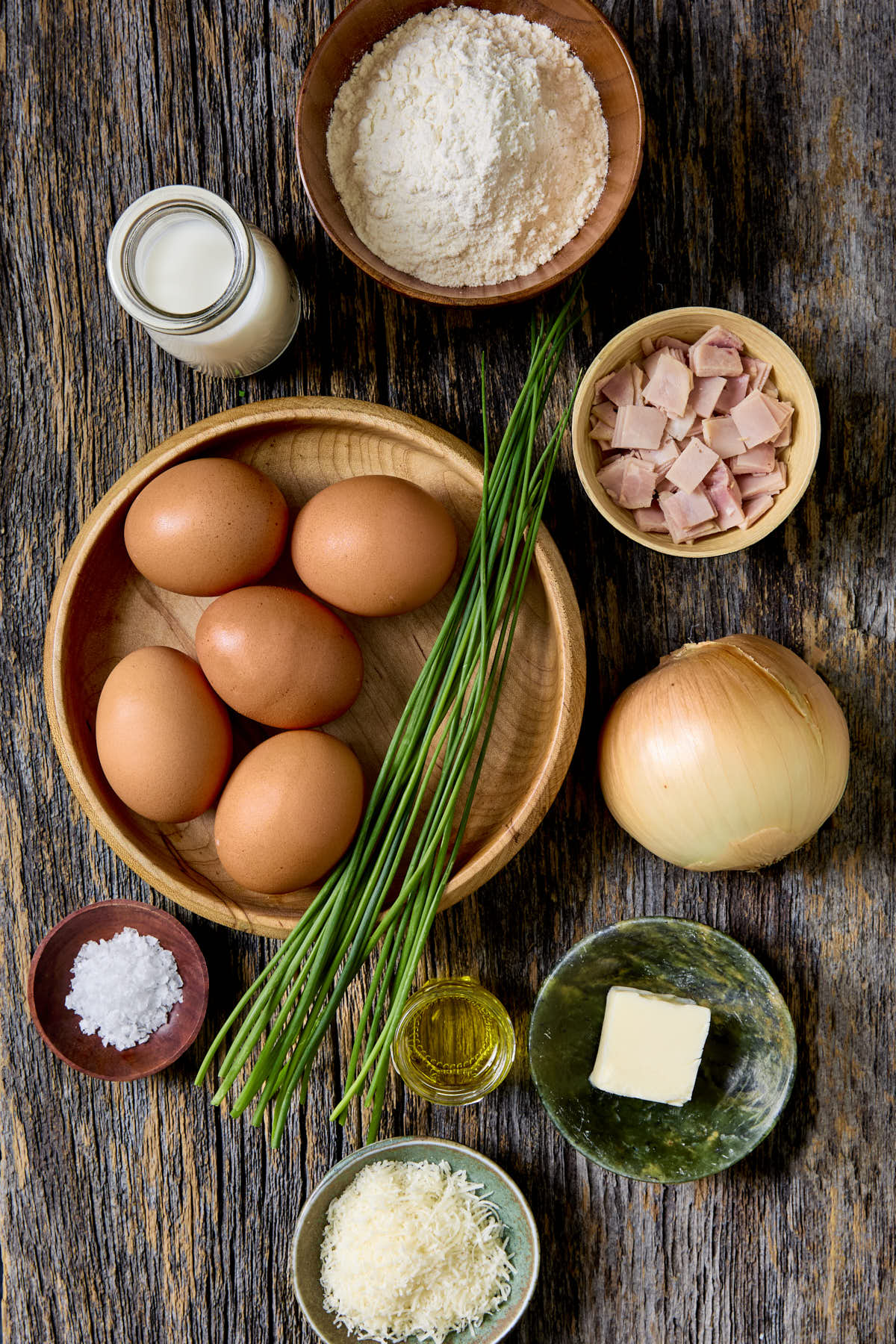 Ingredients to make a savory dutch baby on a wooden board.